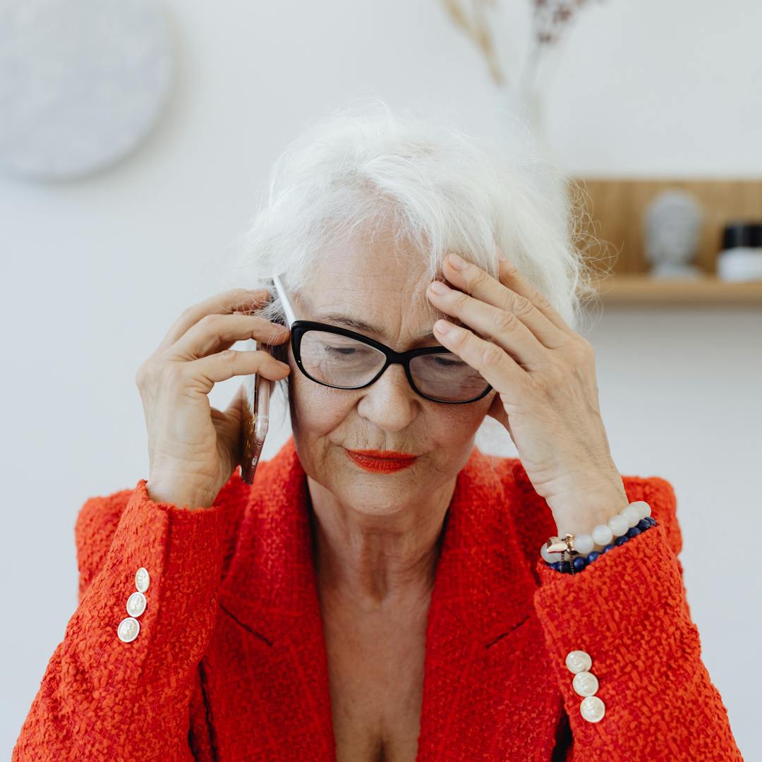 Senhora idosa preocupada ao telefone, conferindo o aumento do seguro de vida